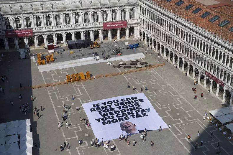 Protestors reveal a giant banner in Venice telling Jeff Bezos to pay more tax ahead of his wedding to Lauren Sanchez.