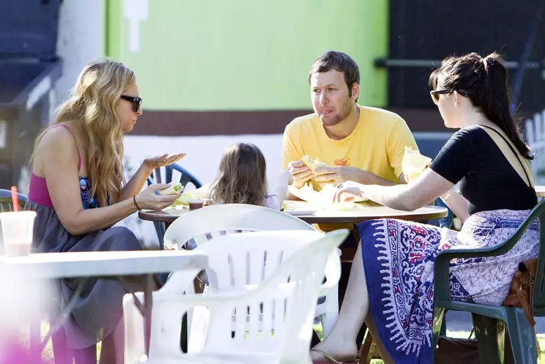 **EXCLUSIVE** Australian actress Toni Collette wipes a bit of food from her mouth while having lunch with her husband Dave Galafassi and daughter Sage Florence