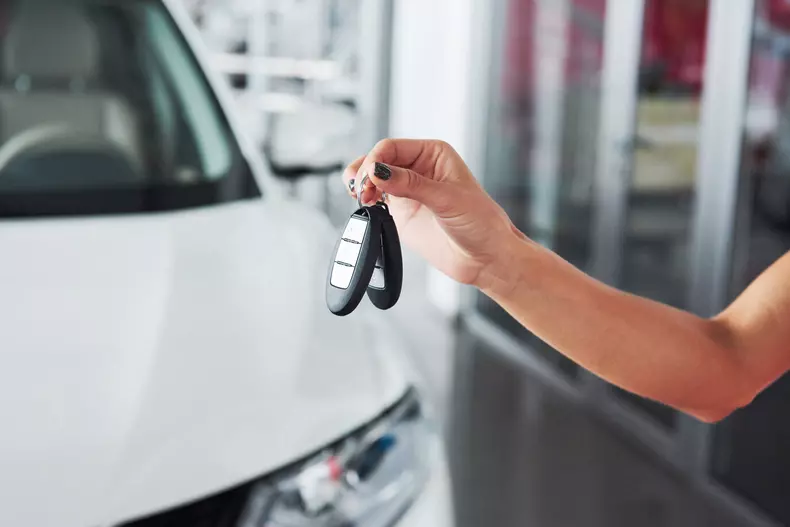 Passing car keys. Cropped closeup of a car dealer holding out car keys to the camera copyspace car dealership salon manager salesman selling buying giving owner profession purchase vehicle concept