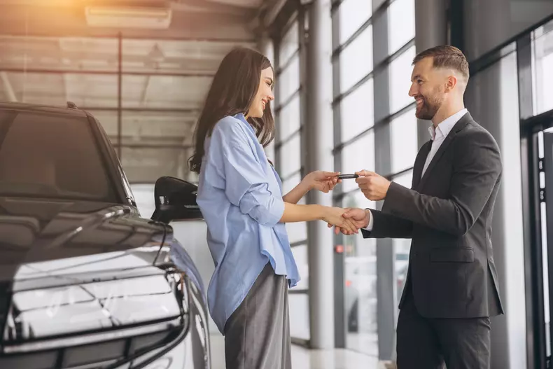 Smiling,Salesman,Or,Manager,Giving,Car,Keys,And,Shakes,Hand