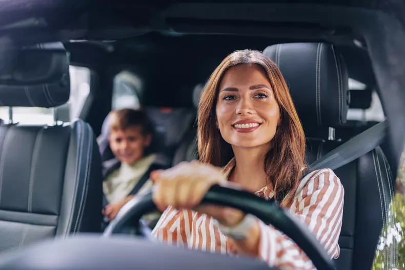 Smiling Mother Driving Son to Elementary School