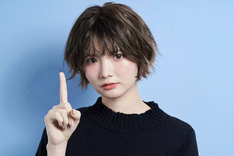 A,Woman,With,Short,Hair,Holding,Up,Her,Index,Finger