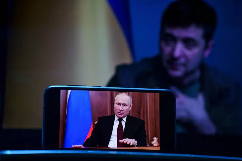 Vladimir Putin speech on TV. Volodymyr Zelensky the president of Ukraine in the background . Volodymyr Zelenskyy speech to people on TV