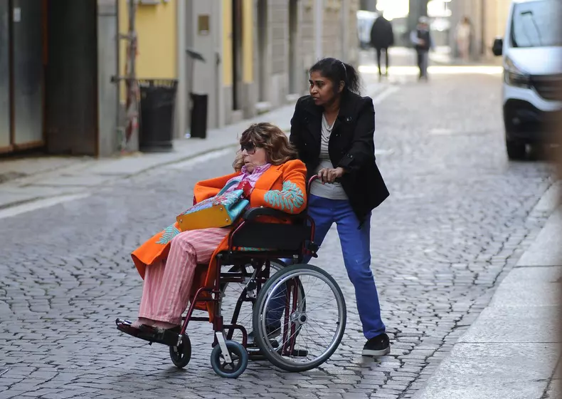 Milan: Patrizia Reggiani arrives downtown in a wheelchair, accompanied by her caregiver and a bodyguard carrying her dog. Her presence doesn't go unnoticed, and to avoid being photographed, she repeatedly asks to change directions. Finally, she asks, and