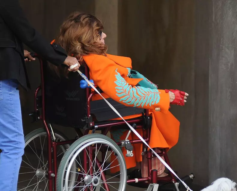 Milan: Patrizia Reggiani arrives downtown in a wheelchair, accompanied by her caregiver and a bodyguard carrying her dog. Her presence doesn't go unnoticed, and to avoid being photographed, she repeatedly asks to change directions. Finally, she asks, and