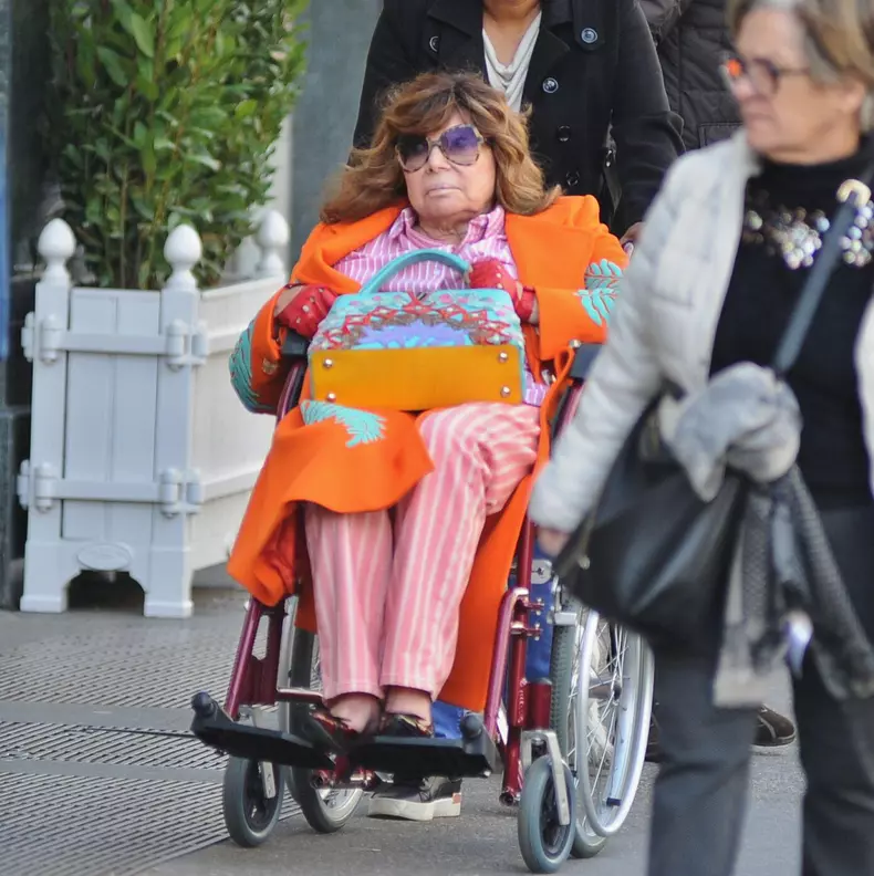 Milan: Patrizia Reggiani arrives downtown in a wheelchair, accompanied by her caregiver and a bodyguard carrying her dog. Her presence doesn't go unnoticed, and to avoid being photographed, she repeatedly asks to change directions. Finally, she asks, and
