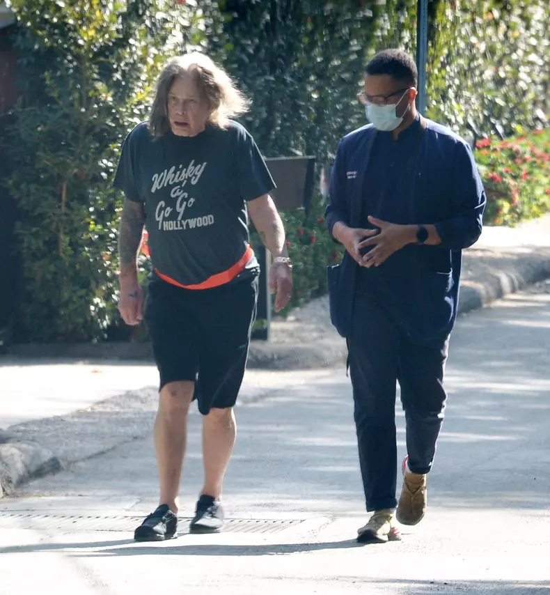 EXCLUSIVE: Ozzy Osbourne is Pictured on a Walk With The Help of an Aide in Los Angeles.