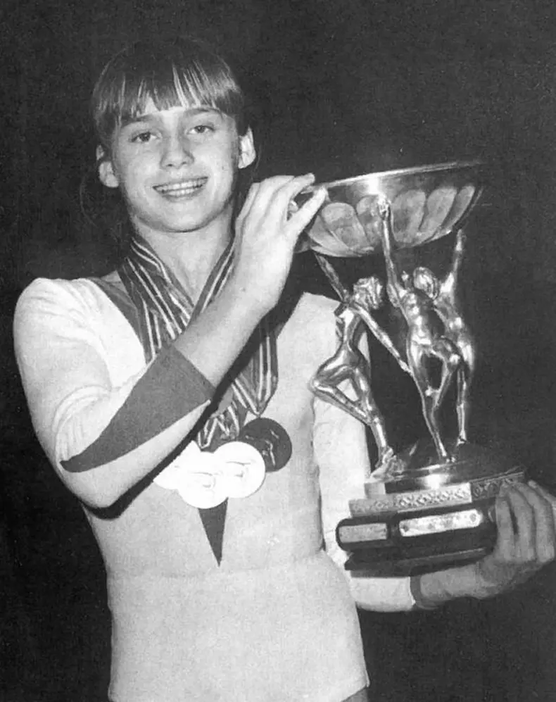 A photograph of Nadia Comaneci, the famed gymnast, taken in Prague in 1977, capturing her athleticism and iconic status in the sport of gymnastics during the peak of her career.