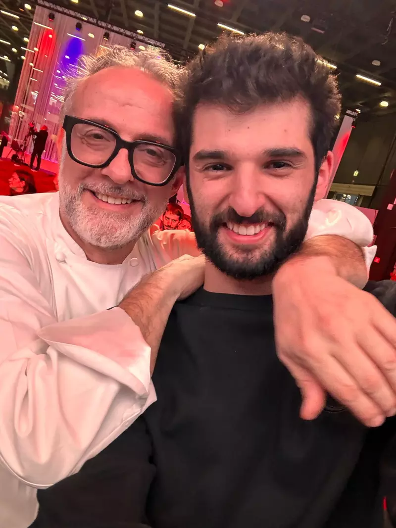 Chef Richard Abou Zaki și Chef Massimo Bottura, la evenimentul cu care a încheiat Congresul Internațional al bucătarilor Identità 2025 de la Milano. Chef Massimo are brațul pe după umerii lui Chef Richard. Amândoi zâmbesc într-un selfie