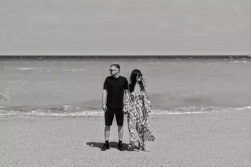 Cosmina Păsărin, despre nuntă. Apare alături de iubitul ei, la mare. Imaginea este alb-negru, iar ei sunt surprinși stând în picioare, ținându-se de mână și privind în direcții diferite.
