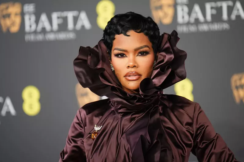 Actrița Teyana Taylor pe covorul roșu la gala BAFTA 2026, purtând o rochie Burberry cu un guler ruff voluminos și o broșă prețioasă.