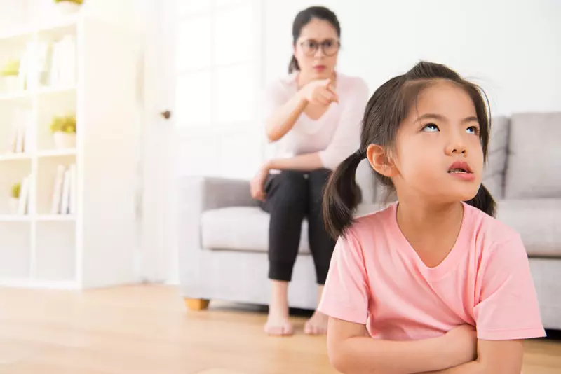 asian mother sitting on the sofa angry pointing