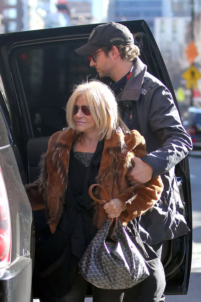 Bradley Cooper helps his mother Gloria out of a large SUV as the pair arrive at their NY hotel