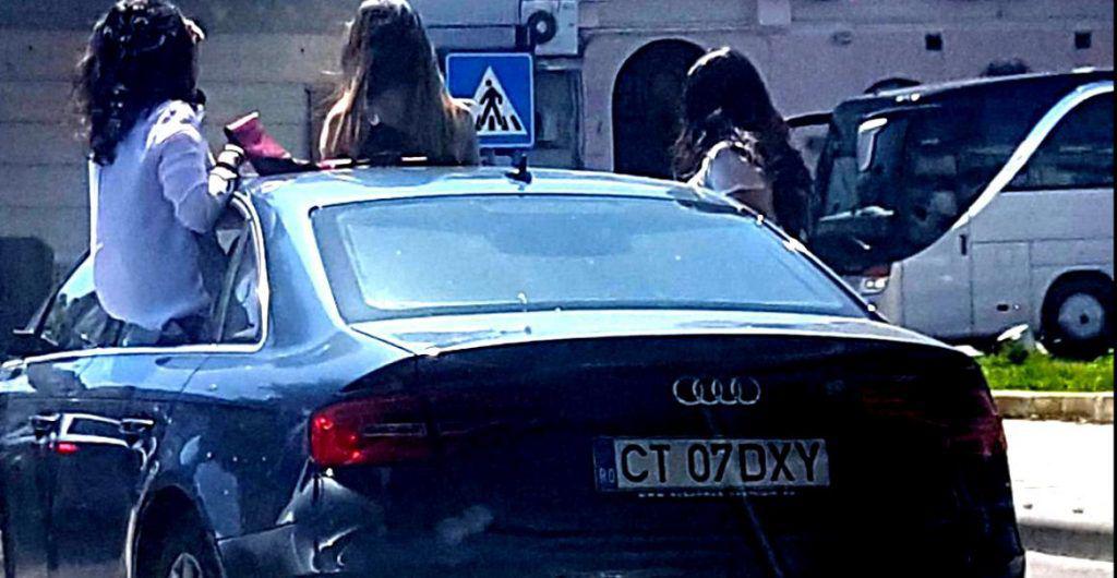 Fete filmate în trafic pe jumătate ieșite din mașină, amendate de polițiști (Video)